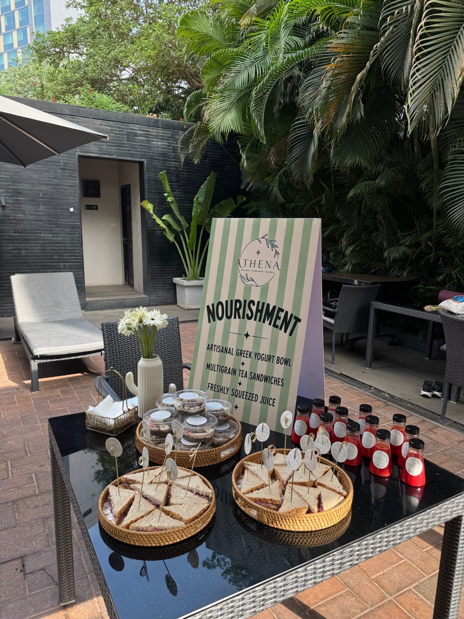 Athena's nourishment table: Greek yogurt bowls, multigrain tea sandwiches and fresh juices beside a striped sign