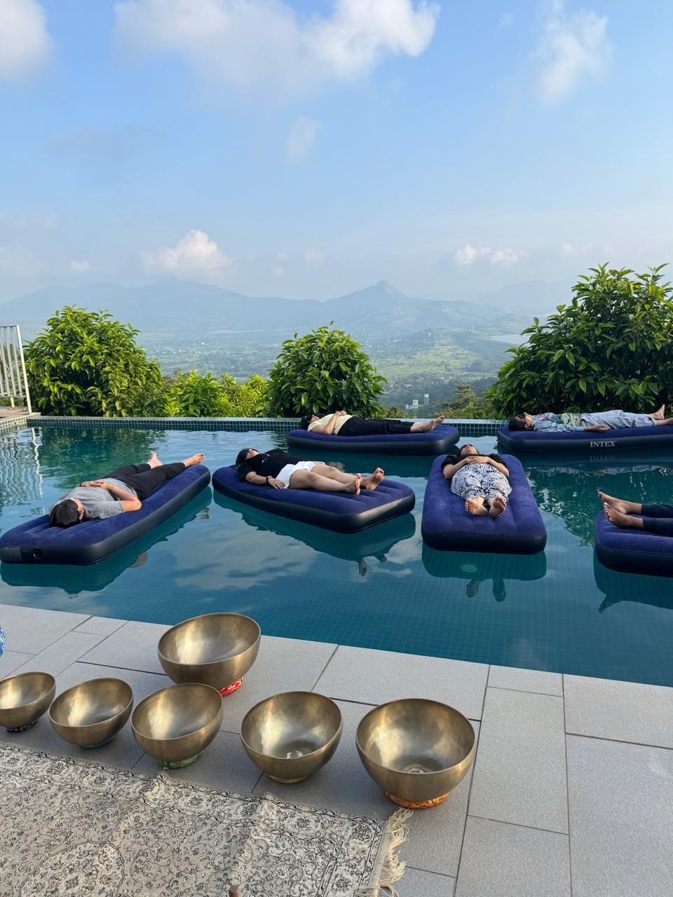 Floating beds on an infinity pool overlooking hills and a wide valley