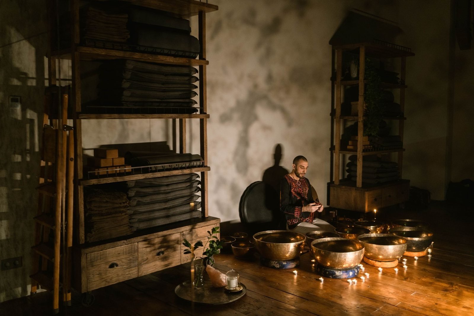 A candlelit room of brass singing bowls during a quiet sound session